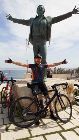Ciclista sotto la statua dedicata al cantante Modugno